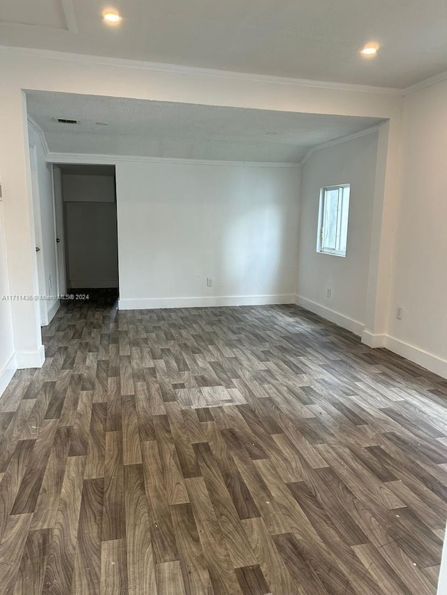 empty room featuring crown molding and dark hardwood / wood-style floors