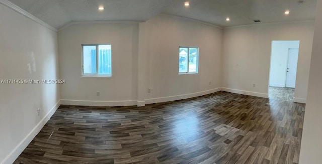 spare room featuring dark hardwood / wood-style floors, ornamental molding, and vaulted ceiling