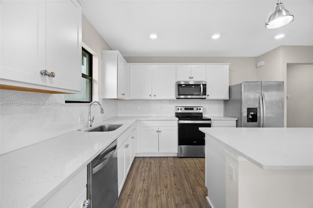 kitchen with sink, dark hardwood / wood-style flooring, pendant lighting, white cabinets, and appliances with stainless steel finishes