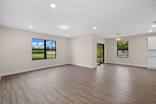 unfurnished room with an inviting chandelier and light wood-type flooring