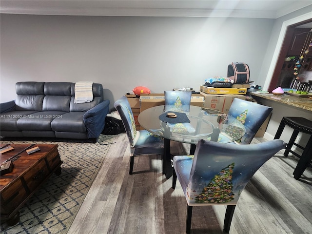 dining area with hardwood / wood-style flooring and crown molding