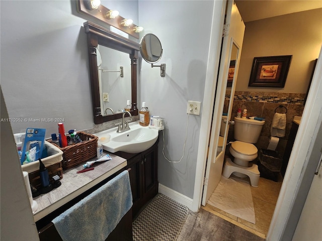 bathroom with hardwood / wood-style floors, vanity, and toilet