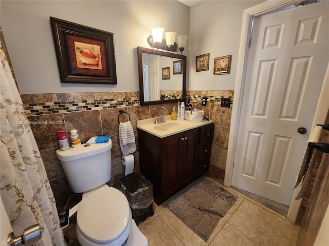 bathroom featuring tile patterned flooring, vanity, toilet, and tile walls