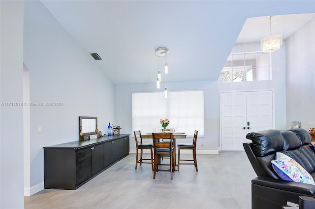 dining space with high vaulted ceiling and an inviting chandelier