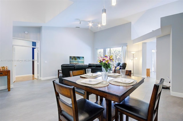 dining area featuring high vaulted ceiling and track lighting