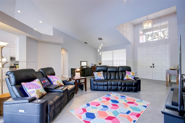 living room with high vaulted ceiling and a notable chandelier