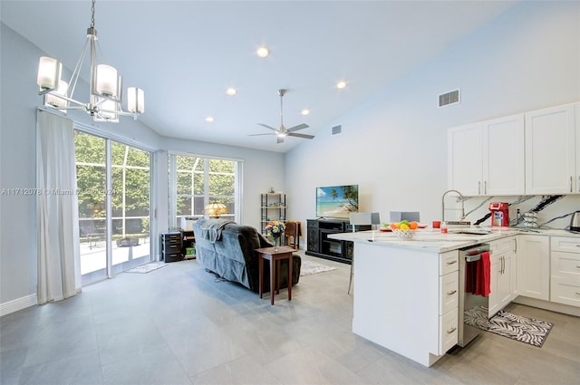 kitchen featuring white cabinetry, dishwasher, tasteful backsplash, decorative light fixtures, and ceiling fan with notable chandelier