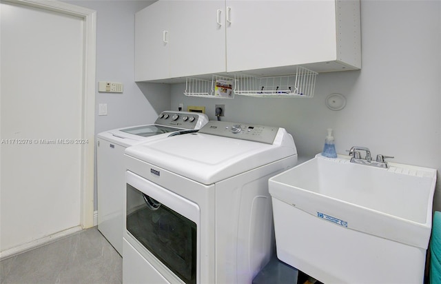 clothes washing area with cabinets, sink, and washing machine and clothes dryer