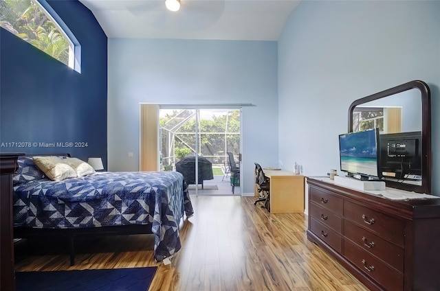 bedroom with access to outside, multiple windows, ceiling fan, and light wood-type flooring