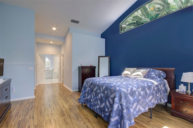 bedroom with hardwood / wood-style floors and lofted ceiling