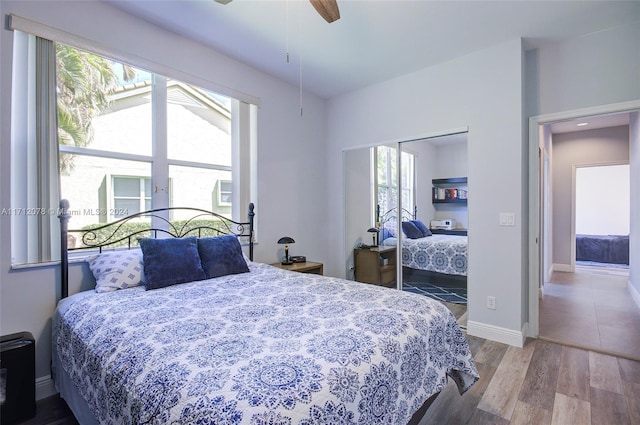 bedroom with a closet, hardwood / wood-style flooring, and ceiling fan