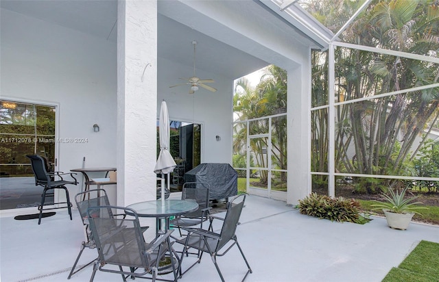 view of patio / terrace featuring ceiling fan and glass enclosure