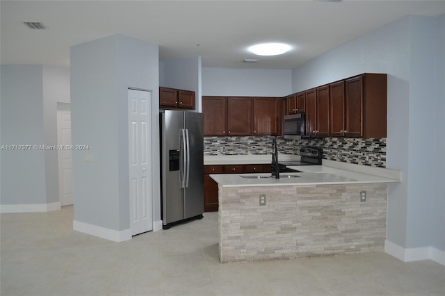 kitchen featuring kitchen peninsula, appliances with stainless steel finishes, tasteful backsplash, sink, and light tile patterned flooring