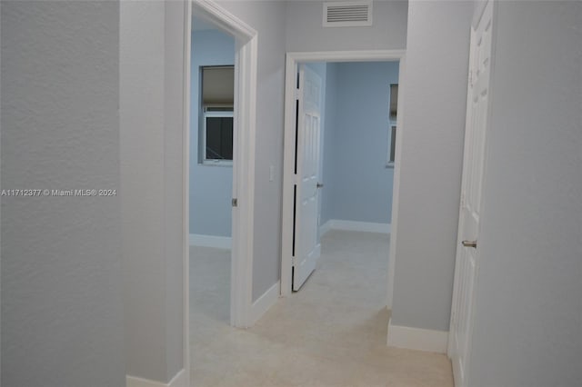 hallway featuring light colored carpet