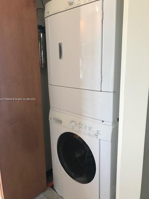 clothes washing area featuring stacked washer / drying machine