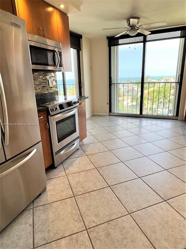 kitchen featuring tasteful backsplash, ceiling fan, light tile patterned flooring, and appliances with stainless steel finishes