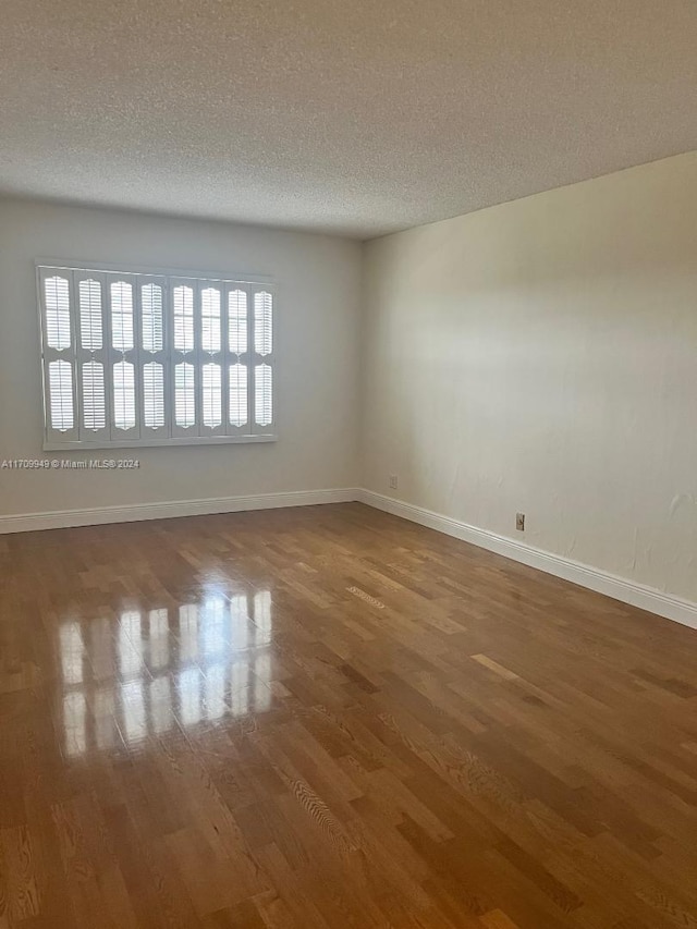 unfurnished room featuring hardwood / wood-style floors and a textured ceiling