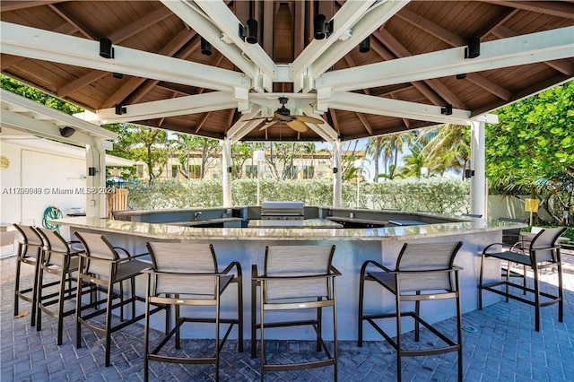 view of patio / terrace featuring a gazebo, ceiling fan, and a bar