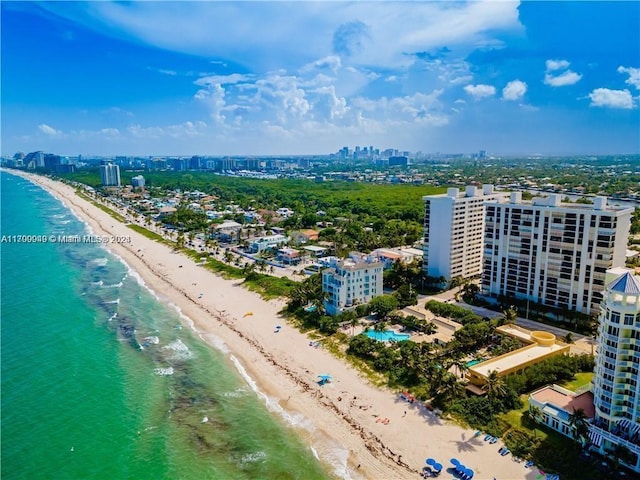 birds eye view of property with a water view and a beach view