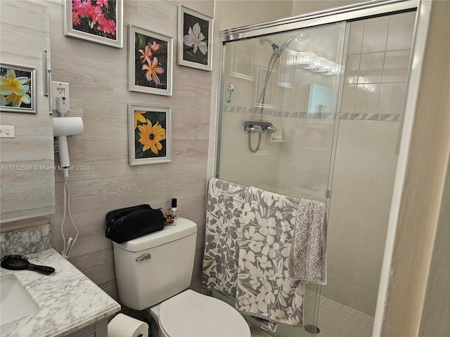 bathroom with vanity, toilet, and a shower with door