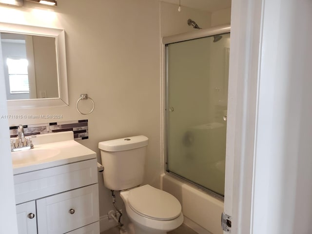 full bathroom with vanity, toilet, and enclosed tub / shower combo