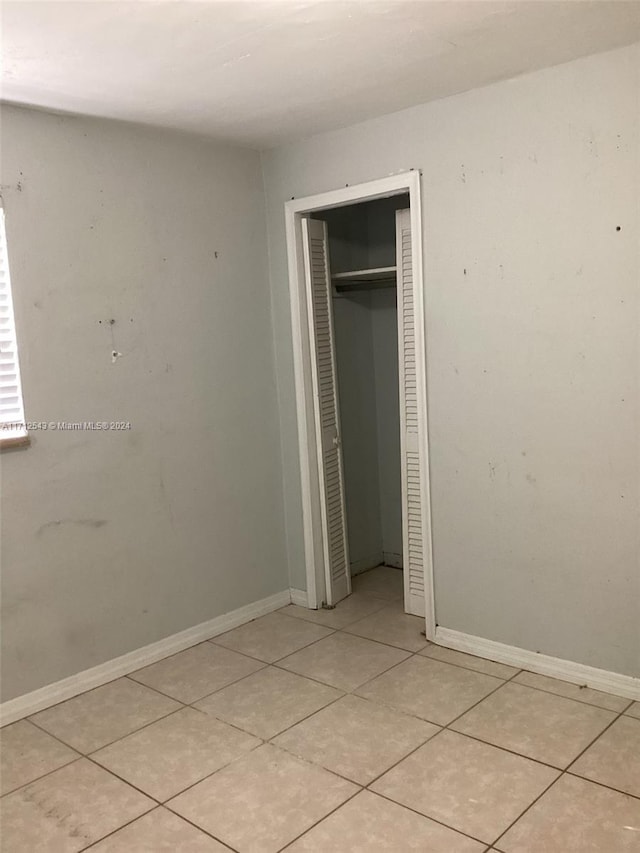 unfurnished bedroom with a closet and light tile patterned floors