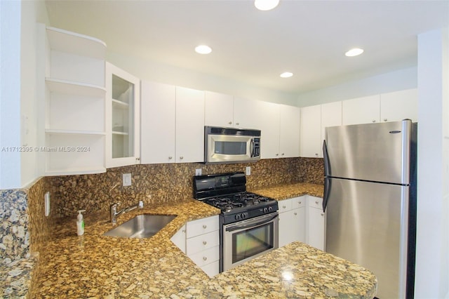 kitchen with stone countertops, white cabinetry, kitchen peninsula, and stainless steel appliances