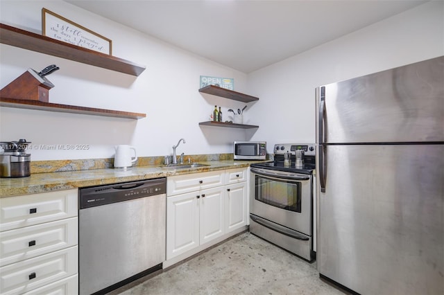 kitchen with light stone counters, sink, white cabinets, and stainless steel appliances