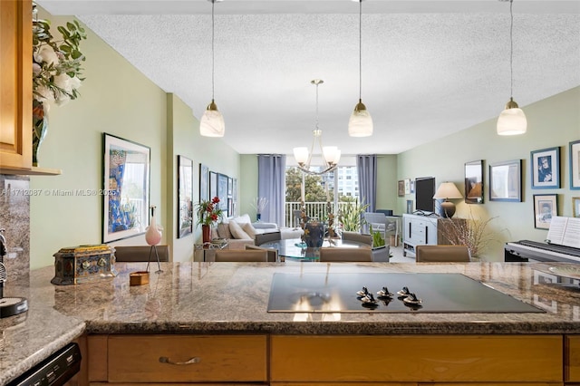 kitchen with black appliances, pendant lighting, a textured ceiling, and open floor plan