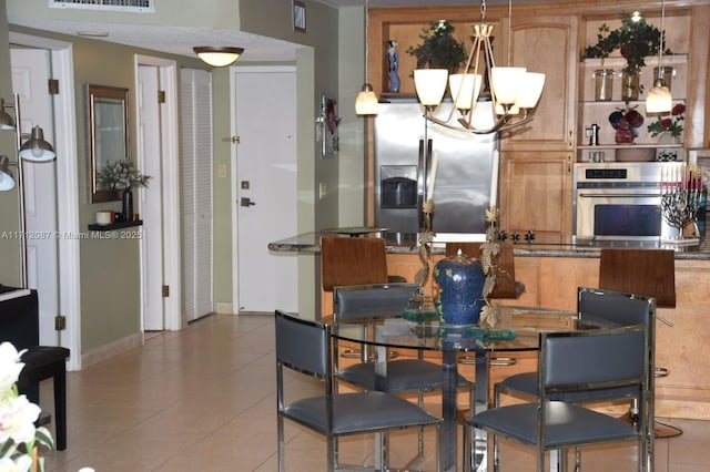 dining room with tile patterned flooring and a notable chandelier