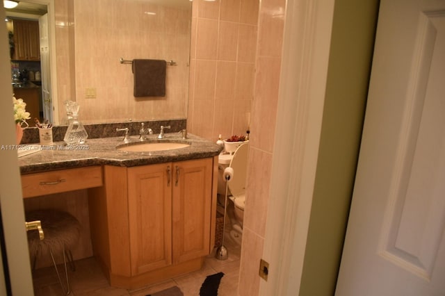 bathroom featuring tile walls, toilet, vanity, and tile patterned floors