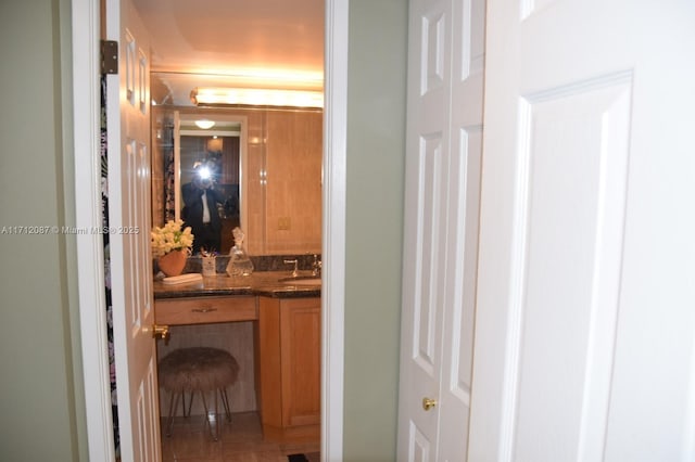 hall featuring tile patterned floors and sink