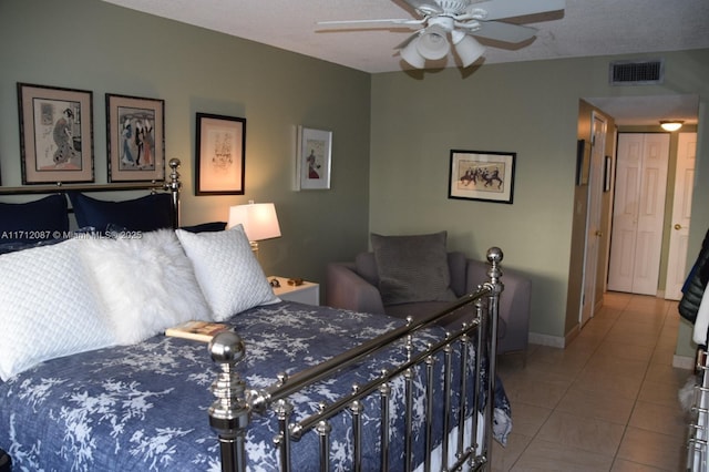 tiled bedroom featuring a textured ceiling and ceiling fan