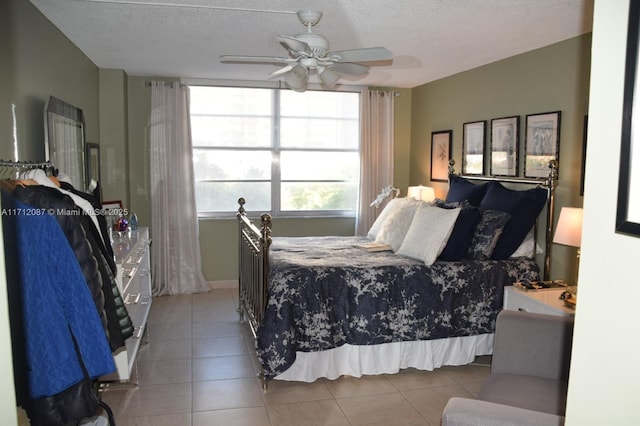 bedroom with a textured ceiling, ceiling fan, and light tile patterned floors