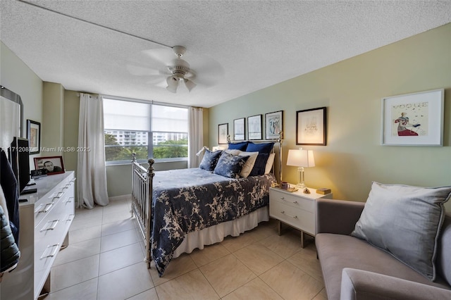 bedroom with a ceiling fan, a textured ceiling, and light tile patterned floors