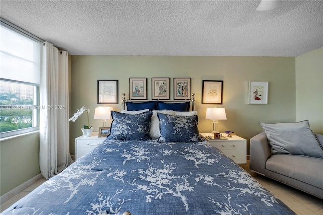 bedroom featuring a textured ceiling and baseboards