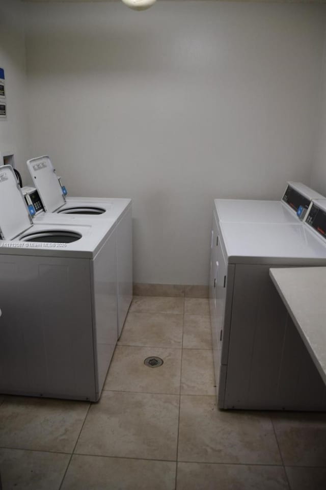 clothes washing area featuring light tile patterned floors and separate washer and dryer