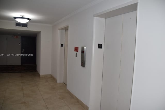 corridor with ornamental molding, light tile patterned floors, and elevator