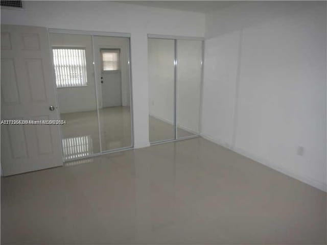 unfurnished bedroom with two closets