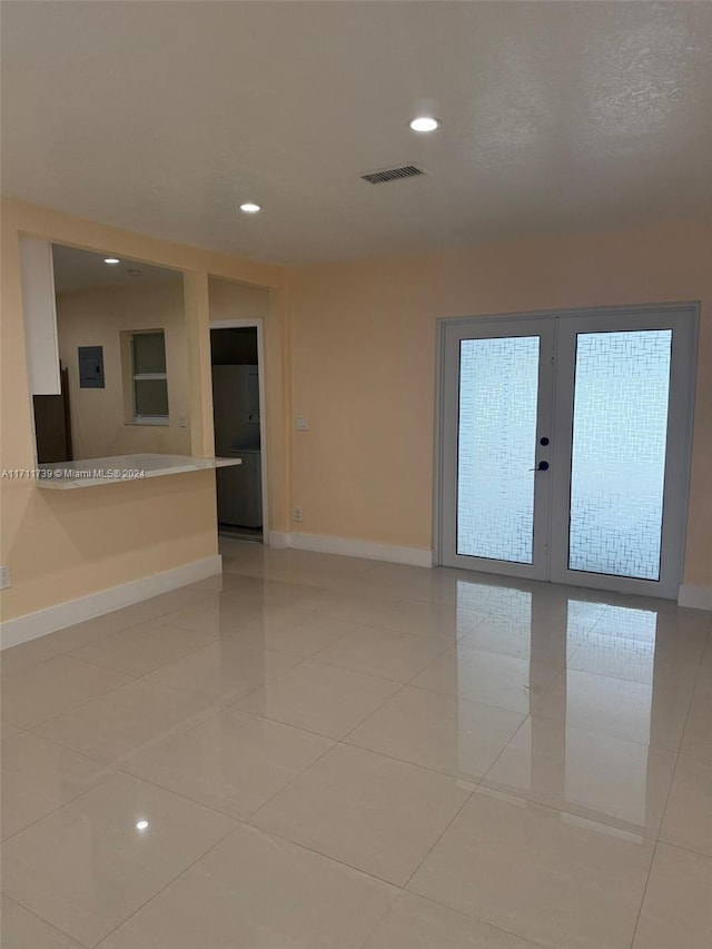 tiled spare room featuring french doors