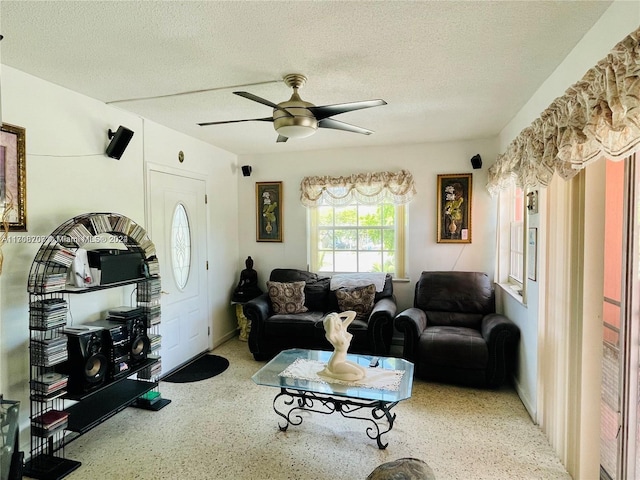 living room featuring a textured ceiling and ceiling fan