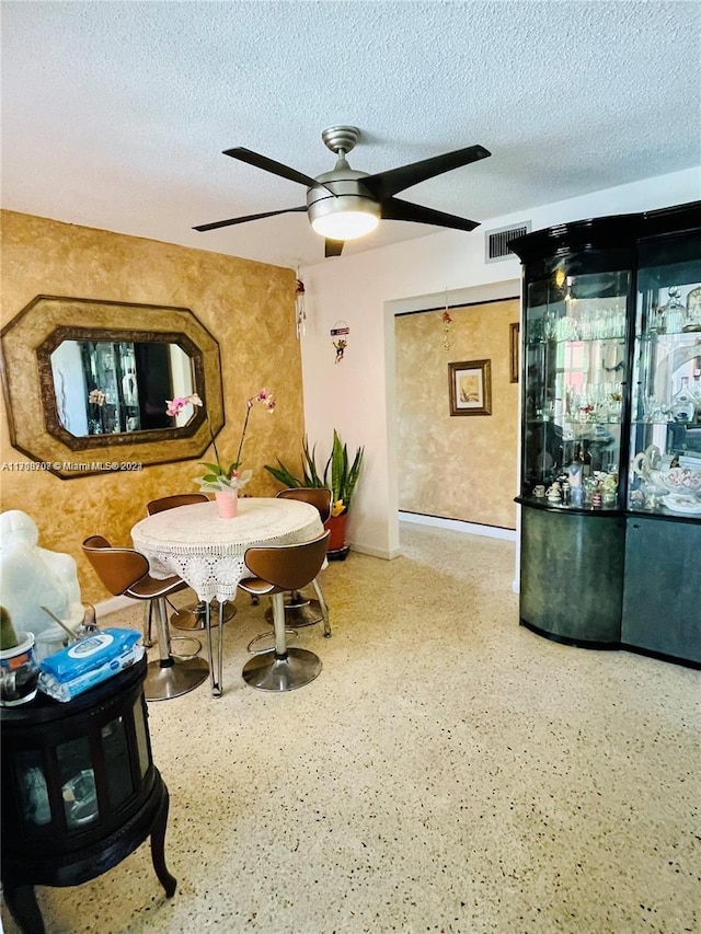 interior space featuring ceiling fan and a textured ceiling