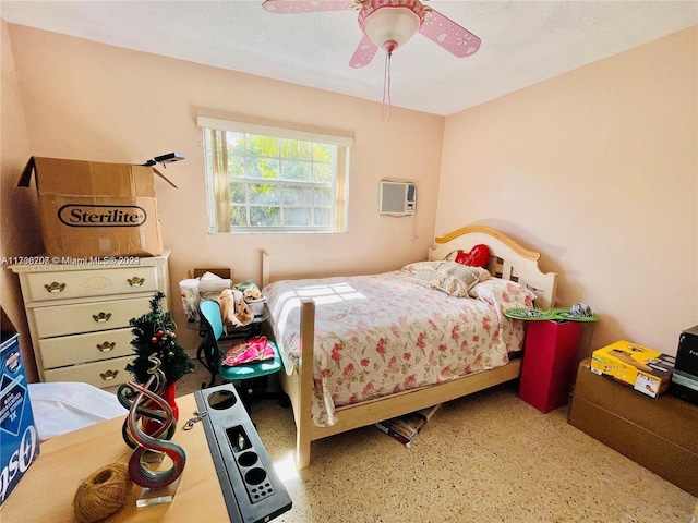 bedroom featuring a textured ceiling, an AC wall unit, and ceiling fan