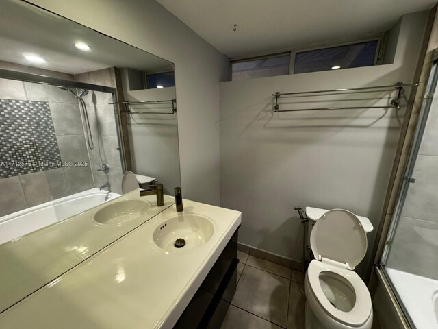 full bathroom featuring enclosed tub / shower combo, tile patterned floors, vanity, and toilet