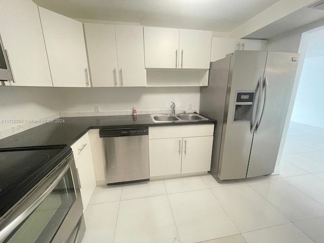 kitchen with stainless steel appliances, white cabinetry, and sink