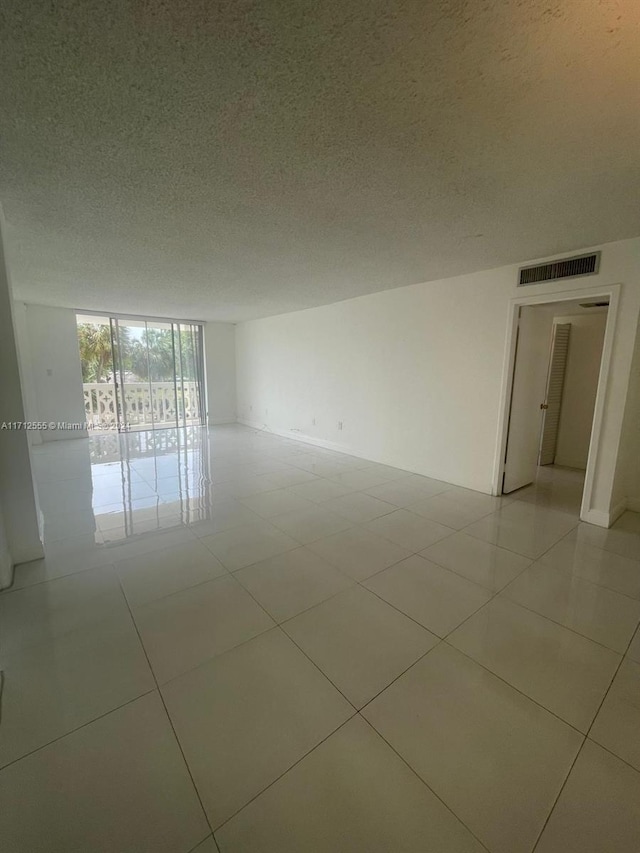 empty room featuring light tile patterned flooring and a textured ceiling