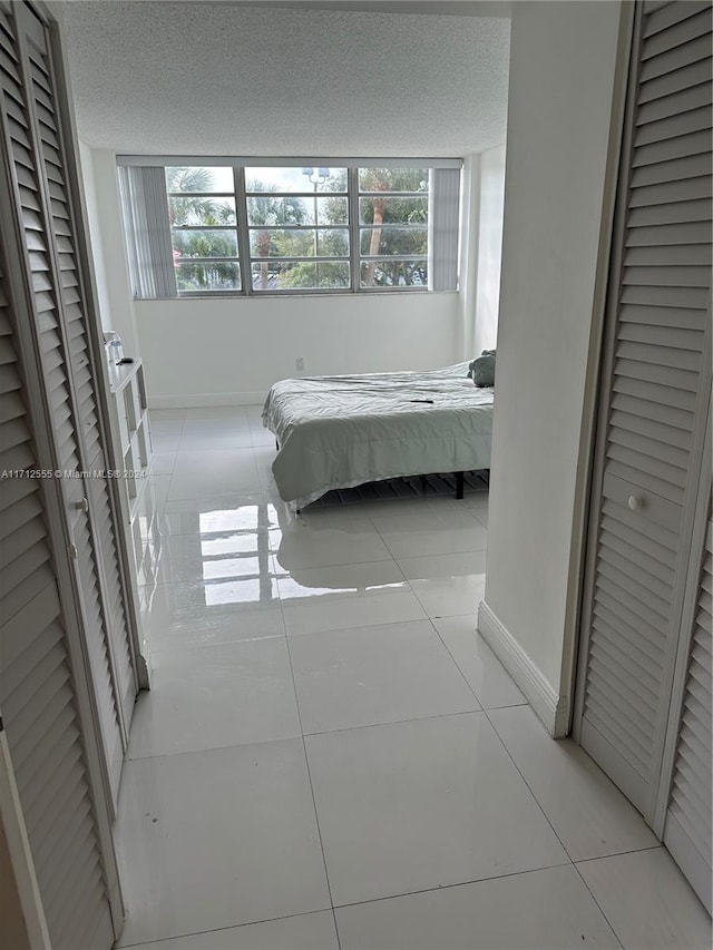 bedroom featuring light tile patterned floors and a textured ceiling