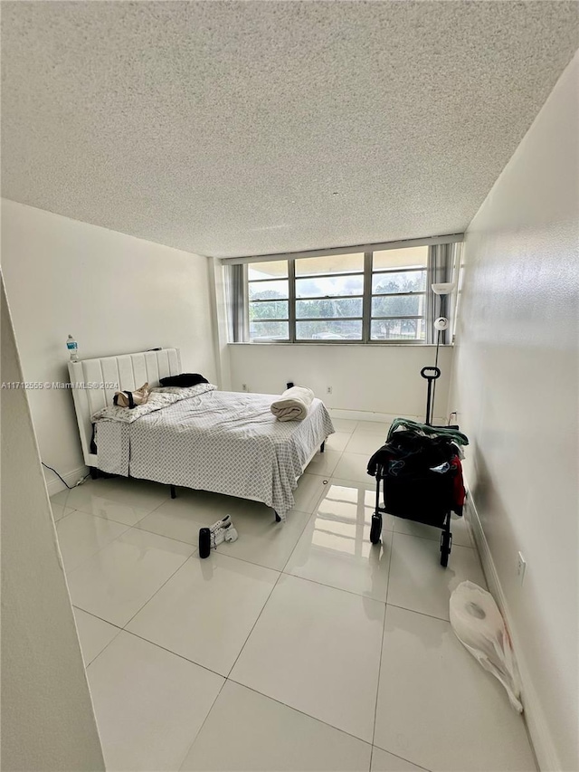 tiled bedroom featuring a textured ceiling