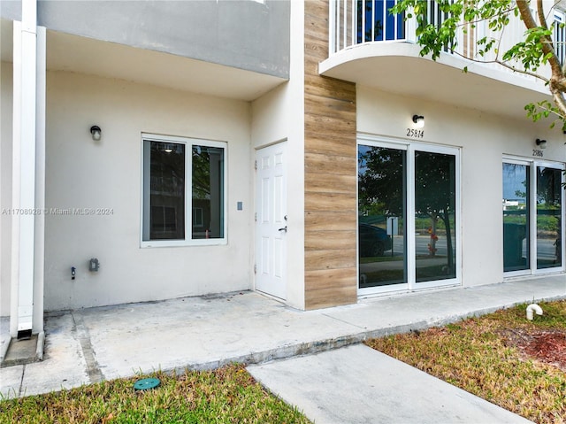 doorway to property with a balcony and a patio