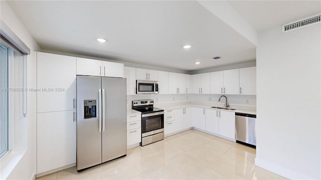 kitchen featuring light tile patterned floors, white cabinetry, sink, and appliances with stainless steel finishes